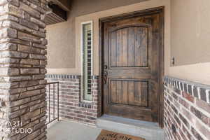 Oversized front doorway to property with stucco siding and brick siding