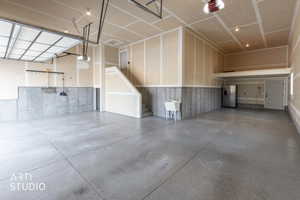 Garage with stainless steel refrigerator  and a garage door opener.  Door exits to backyard.