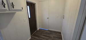Doorway to outside featuring wood finished floors and wooden walls