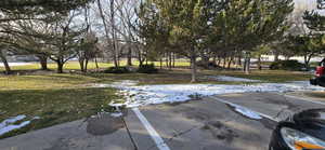 Snowy yard featuring a lawn