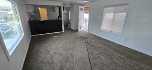 Unfurnished bedroom with dark carpet and baseboards