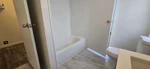 Bathroom featuring a tub to relax in and toilet