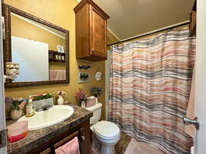 Full bath featuring vanity, curtained shower, and tile patterned flooring