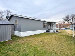 View of front of property with a front yard and a shed