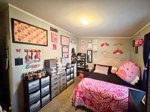 Carpeted bedroom featuring crown molding