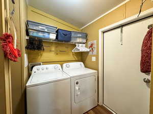 Laundry area with washing machine and dryer, lofted ceiling, and dark wood-style floors