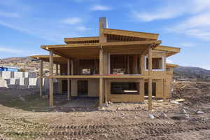 Back of property with a mountain view and a patio