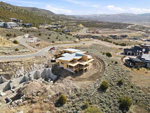 Aerial view of property and surrounding area with a mountainous background and nearby suburban area