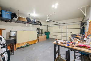 Garage featuring a workshop area and hanging garage storage racks.