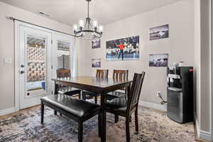Dining room with a chandelier and LVP flooring.