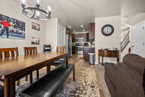 Dining room with a bright chandelier, view of kitchen and family room.