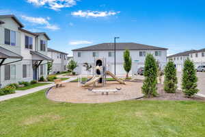 Community play area with a residential view and a lawn