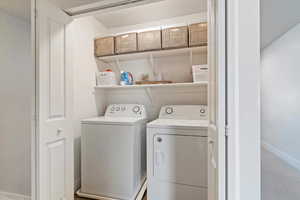 Laundry room with washer and dryer and baseboards