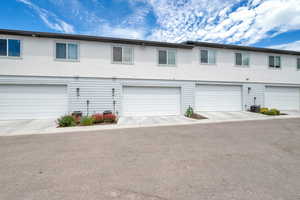 View of front facade featuring stucco siding, driveway, and a garage