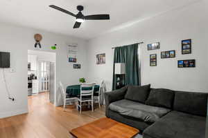 Living area with light wood finished floors and a ceiling fan