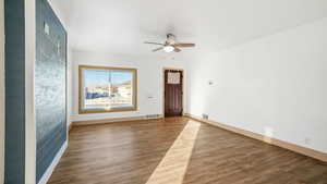 Empty room with wood finished floors and a ceiling fan