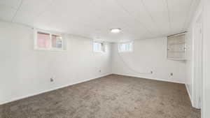 Basement featuring carpet flooring and baseboards