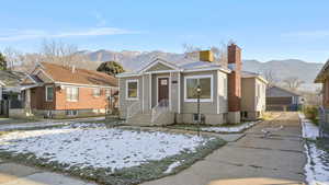 Bungalow-style house featuring a mountain view, a detached garage, a chimney, and a gate
