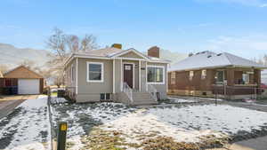 Bungalow-style house featuring an outbuilding, a chimney, a garage, and a mountain view