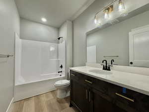 Bathroom featuring vanity, shower / tub combination, and light wood-type flooring