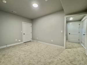 Empty room with carpet and a smoke detector