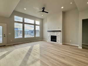 Unfurnished living room featuring ceiling fan, light wood-type flooring, a fireplace, and recessed lighting