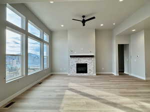 Unfurnished living room featuring ceiling fan, light wood-type flooring, a fireplace, and recessed lighting