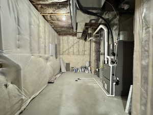 Unfinished below grade area featuring heating unit and electric panel