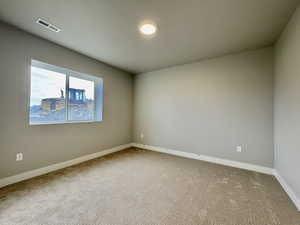 Empty room featuring baseboards and carpet flooring