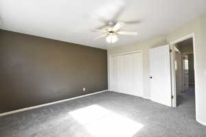 Unfurnished bedroom featuring a closet, carpet, and ceiling fan