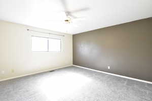 Unfurnished room featuring carpet and ceiling fan