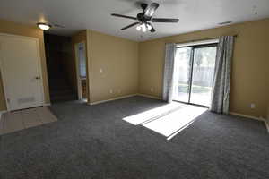 Spare room with stairs, light colored carpet, and ceiling fan