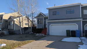 View of front facade featuring concrete driveway and an attached garage