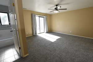 Carpeted spare room featuring baseboards and a ceiling fan