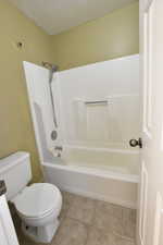 Bathroom featuring light tile patterned flooring and washtub / shower combination