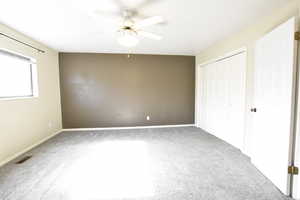 Unfurnished bedroom with light colored carpet, a closet, and a ceiling fan