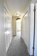 Hallway featuring carpet flooring and baseboards