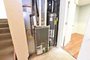 Utility room featuring water heater and heating unit