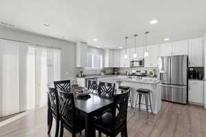 Dining room featuring light wood-style floors and recessed lighting