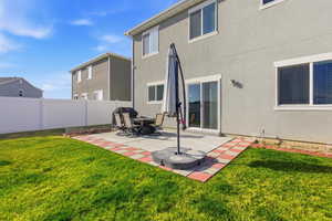 Back of property featuring stucco siding, a patio area, and a fenced backyard