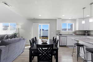 Dining area with light wood-style floors, plenty of natural light, a textured ceiling, and recessed lighting