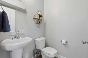 Half bathroom with toilet and baseboards