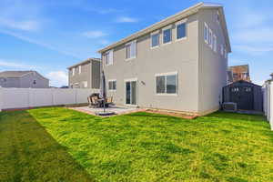 Rear view of property featuring a patio, a storage unit, a fenced backyard, and stucco siding
