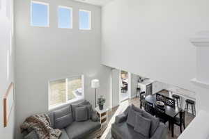 Living area with wood finished floors and a towering ceiling