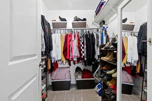Walk in closet with light colored carpet