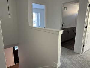 Corridor with a sink and dark carpet