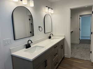 Master  bathroom with double vanity and dark wood-style floors