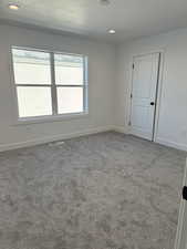 Spare room with a textured ceiling, dark colored carpet, and recessed lighting