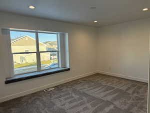 Spare room with recessed lighting and dark colored carpet