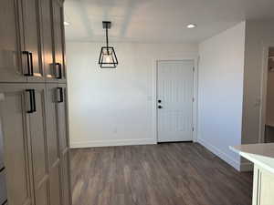Unfurnished dining area with dark wood-style floors and recessed lighting